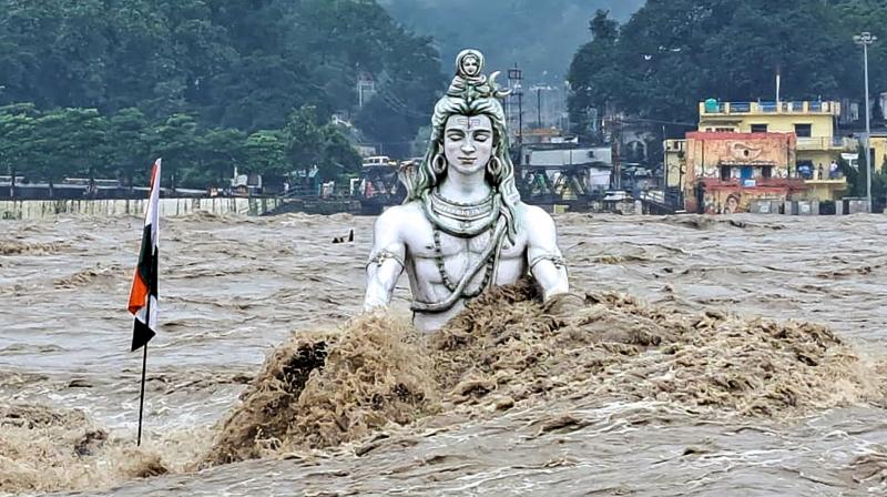 Rishikesh: An idol of Lord Shiva partially submerged in swollen Ganga river after monsoon rains, at Parmarth Niketan Ghat in Rishikesh, Monday, Aug. 14, 2023. (PTI Photo)