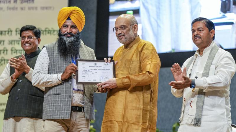 New Delhi: Union Home Minister and Minister of Cooperation Amit Shah distributes membership certificates to National Cooperative Exports Limited (NCEL) members during the National Symposium on Cooperative Exports organised by NCEL, in New Delhi, Monday, Oct. 23, 2023. Union Minister for Commerce and Industry Piyush Goyal and Union MoS of Cooperation BL Verma are also seen. (PTI Photo/Arun Sharma)