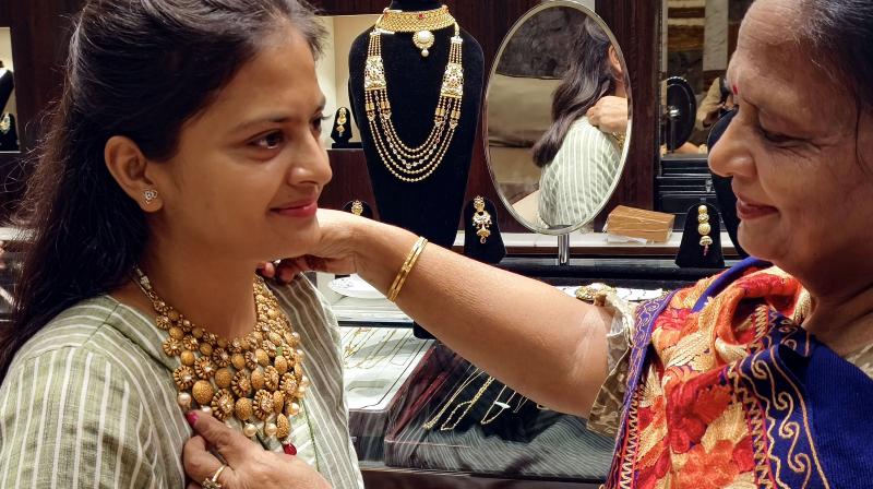 Patiala: A woman tries jewellery on Dhanteras, in Patiala, Friday, Nov. 10, 2023. (PTI Photo) 