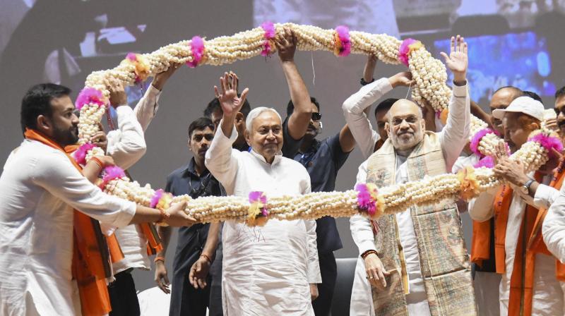 Patna: Union Home Minister Amit Shah along with Bihar Chief Minister Nitish Kumar being garlanded at a state-level cooperative conference, in Patna, Sunday, March 30, 2025. (PTI Photo) (PTI03_30_2025_000071A)