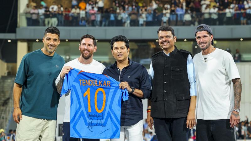 from left, Uruguayan footballer Luis Suarez, Argentine football superstar Lionel Messi, cricket legend Sachin Tendulkar, Maharashtra Chief Minister Devendra Fadnavis and Argentine footballer Rodrigo De Paul during an event as part of the 'GOAT India Tour 2025', at the Wankhede Stadium, in Mumbai. (@Dev_Fadnavis/X via PTI Photo)