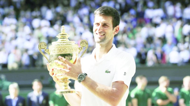 Novak Djokovic holds with winners trophy