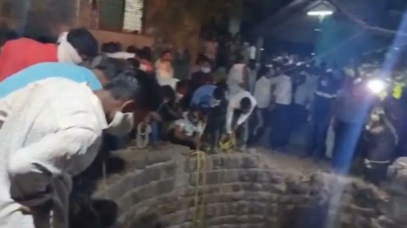 People rescuing a cat that fell into a well