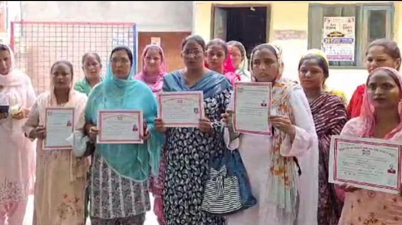 ਔਰਤਾਂ ਸਰਟੀਫਿਕੇਟ ਦਿਖਾਉਂਦੀਆਂ ਹੋਈਆਂ 