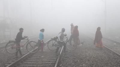 Patna: Commuters cross railway tracks amid fog on a cold winter morning, in Patna, Friday, Dec. 29, 2023. (PTI Photo)