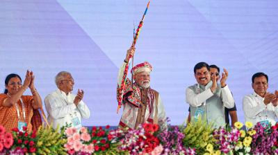 Prime Minister Narendra Modi holds a bow and arrow during the foundation stone laying ceremony of the PM MITRA Park and inauguration of various campaigns, in Dhar. Madhya Pradesh Governor Mangubhai C. Patel and state Chief Minister Mohan Yadav also seen. (PMO via PTI Photo)