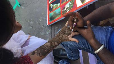 ਵਿਆਹ ਵਾਲੀ ਲੜਕੀ ਨੂੰ ਮਹਿੰਦੀ ਲਗਾਉਂਦੇ ਹੋਏ