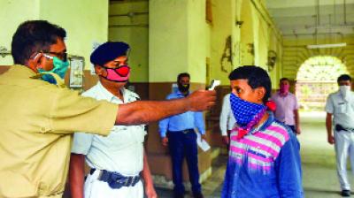 ਕਲਕ¾ਤਾ ’ਚ ਇਕ ਪੁਲਿਸ ਮੁਲਾਜ਼ਮ ਮਸ਼ਹੂਰ ਰਾਈਟਰਸ ਬਿਲਡਿੰਗ ’ਚ ਦਾਖ਼ਲੇ ਸਮੇਂ ਵਿਅਕਤੀ ਦੇ ਸਰੀਰ ਦੇ ਤਾਪਮਾਨ ਦੀ ਜਾਂਚ ਕਰਦਾ ਹੋਇਆ। 	ਪੀਟੀਆਈ