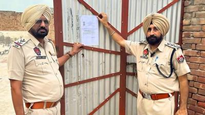 ਪੁਲਿਸ ਨਸ਼ਾ ਤਸਕਰ ਦੇ ਘਰ ਦੇ ਬਾਹਰ ਨੋਟਿਸ ਲਗਾਉਂਦੀ ਹੋਈ 