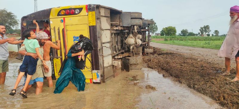 A bus full of overturned passengers in the fields