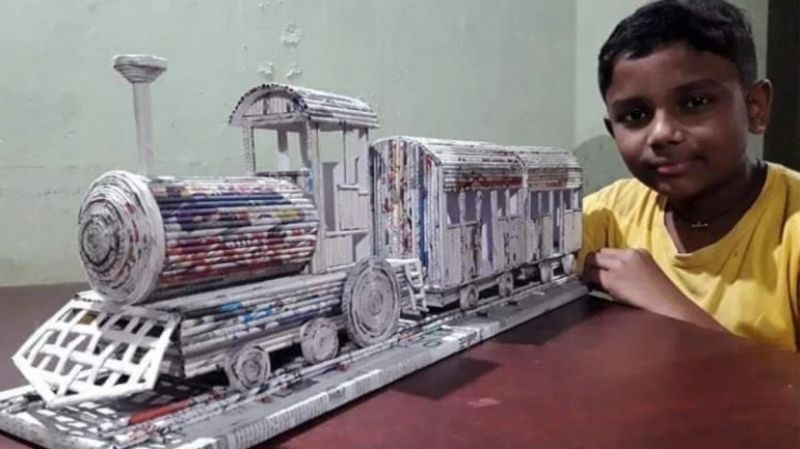 Boy creates train model using newspaper 