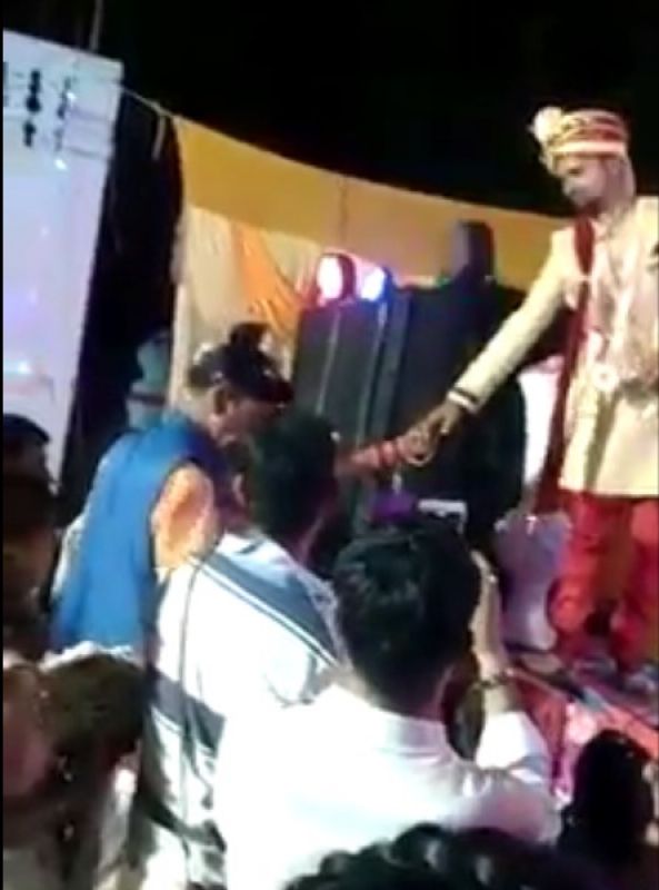 The bride climbed on the stage, fired, then grabbed the groom's hand