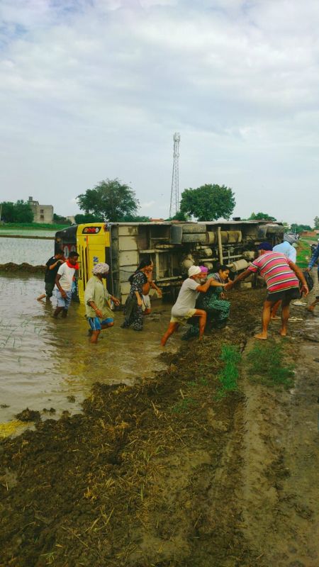 A bus full of overturned passengers in the fields