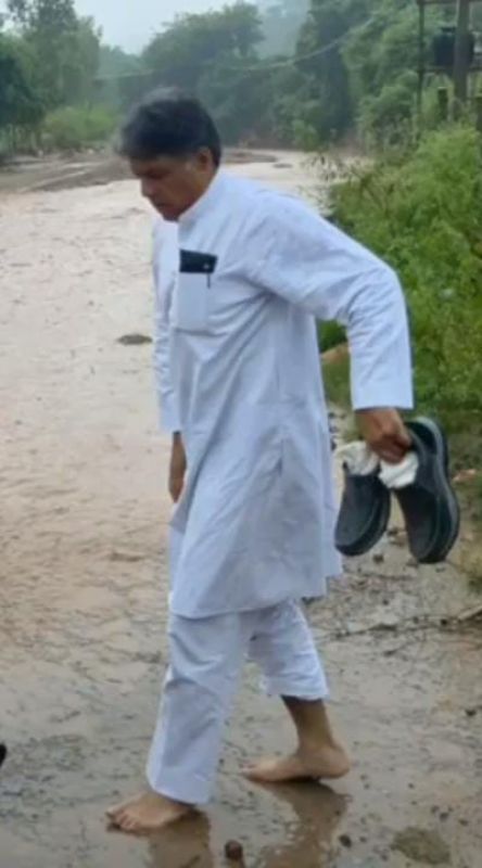 Manish Tewari crosses a rivulet on the way to Tanda village