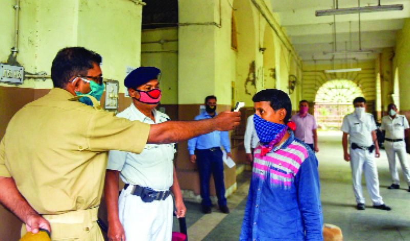 ਕਲਕੱਤਾ 'ਚ ਇਕ ਪੁਲਿਸ ਮੁਲਾਜ਼ਮ ਮਸ਼ਹੂਰ ਰਾਈਟਰਸ ਬਿਲਡਿੰਗ 'ਚ ਦਾਖ਼ਲੇ ਸਮੇਂ ਵਿਅਕਤੀ ਦੇ ਸਰੀਰ ਦੇ ਤਾਪਮਾਨ ਦੀ ਜਾਂਚ ਕਰਦਾ ਹੋਇਆ।  ਪੀਟੀਆਈ