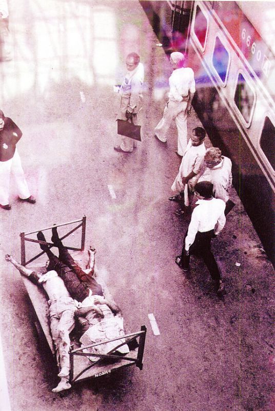 ਰੇਲਵੇ ਸਟੇਸ਼ਨ 'ਤੇ ਪਈਆਂ ਸਿੱਖਾਂ ਦੀਆਂ ਲਾਵਾਰਸ ਲਾਸ਼ਾਂ ਨੂੰ ਵੇਖ ਕੇ ਲੰਘਦੇ ਹੋਏ ਲੋਕ।