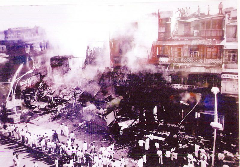 ਸਿੱਖਾਂ ਦੇ ਸੜ ਰਹੇ ਘਰਾਂ ਅਤੇ ਦੁਕਾਨਾਂ ਨੂੰ ਵੇਖਦੇ ਹੋਏ ਲੋਕ।