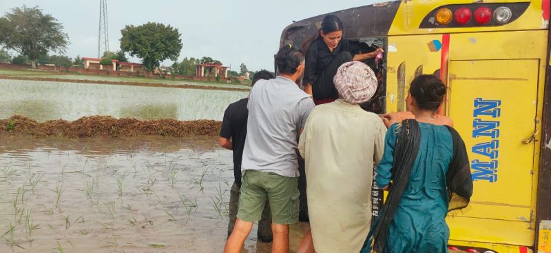 A bus full of overturned passengers in the fields