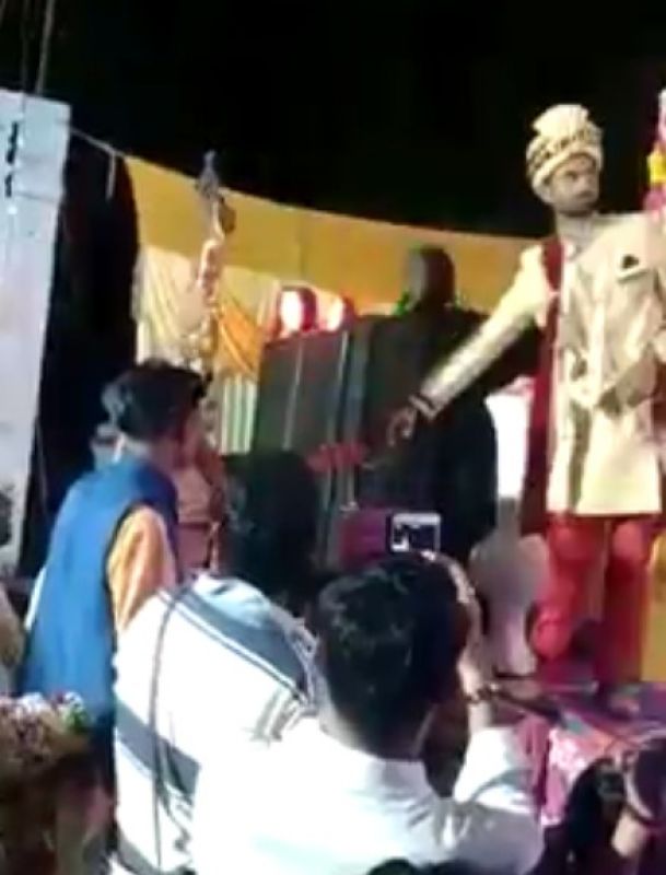 The bride climbed on the stage, fired, then grabbed the groom's hand